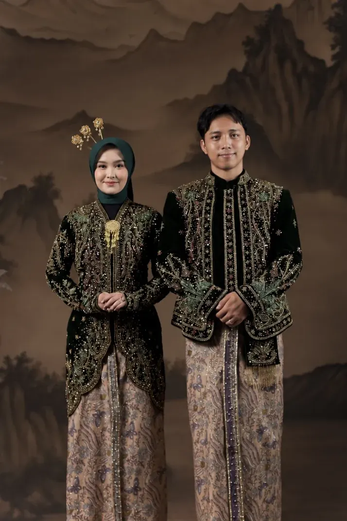 Ibnu dan Rheinata berdiri bersama dalam busana adat Jawa
